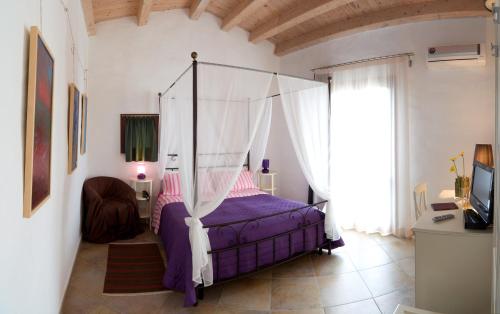 圣夫拉维亚吉安努恩住宿加早餐旅馆的一间卧室配有一张带天蓬的床
