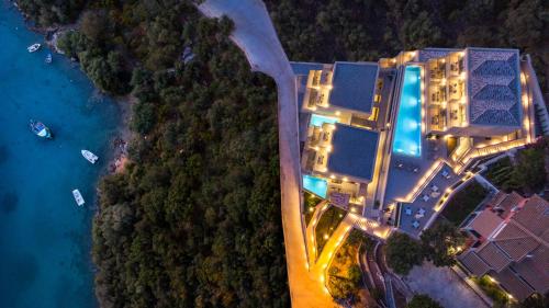 塞沃塔Sivota Deamaris Luxury Boutique Hotel的享有度假村的顶部景色,晚上设有游泳池