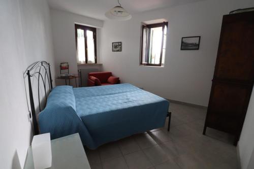 BoissanoAppartamento in borgata storica的一间卧室配有蓝色的床和椅子