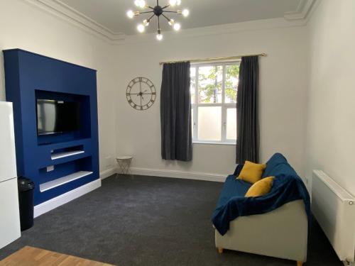 利明顿温泉Lovely 1 bed ground floor flat in Leamington Spa的客厅配有蓝色的沙发和电视