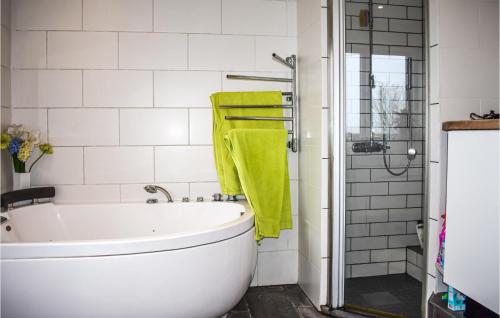 KöpingebroPet Friendly Home In Kpingebro With House A Panoramic View的浴室设有白色浴缸和绿毛巾。