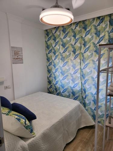 马拉加APARTAMENTO SH的一间卧室设有一张床和蓝白色的墙壁