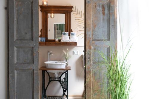 阿斯蒂Donna Elena - Epoque Residence的一道古老的门通向一个带水槽的浴室
