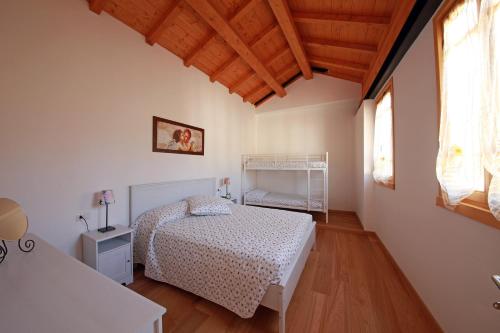 萨罗斯卡拉农庄酒店的卧室配有白色的床,铺有木地板