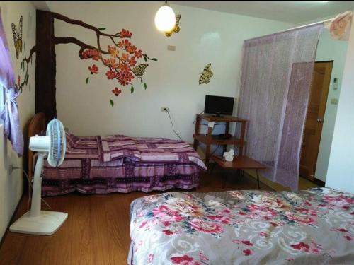 Lanyu兰屿我家の民宿的一间卧室配有一张床和一张带风扇的桌子。