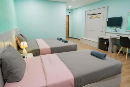 Ban Khlong WaSritrang Residence的客房设有两张床、一张桌子和一台电视。