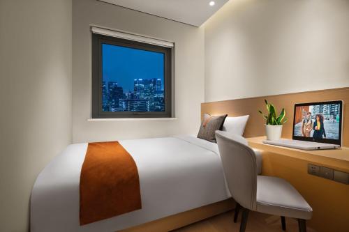 成都成都馨乐庭高新公寓酒店的一间卧室配有一张床、一张书桌和一个窗户。