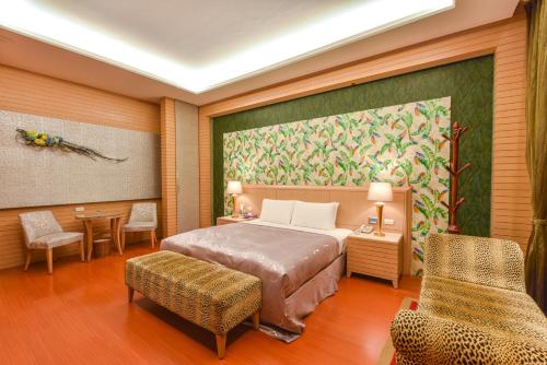 高雄紫园汽车旅馆 的卧室配有一张床,墙上挂有绘画作品
