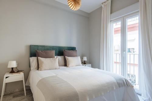 塞维利亚Magno Apartments Guadalquivir Terrace的白色的卧室设有一张大床和一个窗户