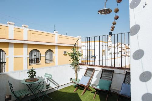塞维利亚Magno Apartments Guadalquivir Terrace的大楼内的阳台配有桌椅