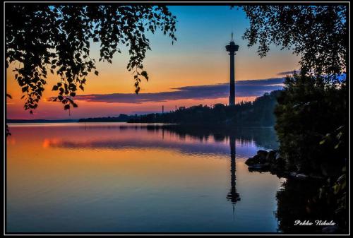 坦佩雷Lapinniemen kattohuoneistot Tampereella的享有远处湖泊和水塔的景色