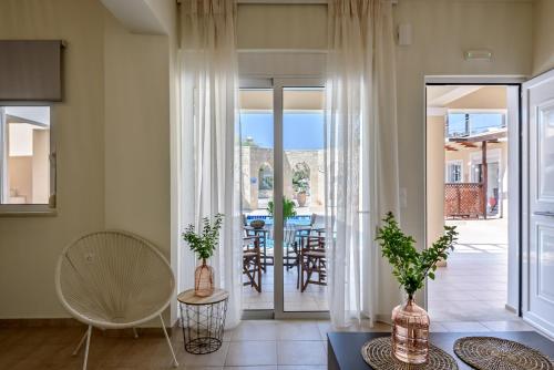 基萨莫斯湛蓝海滩别墅酒店的客厅设有滑动玻璃门和桌椅