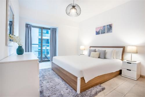 迪拜Icon Casa Living - Princess Tower的白色的卧室设有一张大床和一个窗户