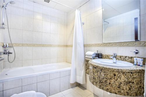 迪拜Icon Casa Living - Princess Tower的带浴缸、水槽和浴缸的浴室