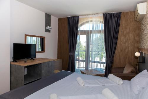 金沙拖罗内格罗酒店的一间卧室设有一张床、一台电视和一个窗口。