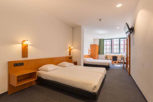 安特卫普安特卫普中心世纪酒店的酒店客房设有两张床和一张桌子。