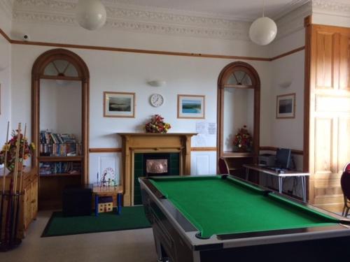 勒威克Islesburgh House Hostel的客厅设有台球桌和壁炉。