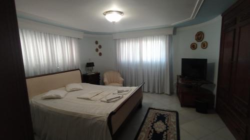 卡瓦拉Villa Luxury的一间卧室配有一张带白色床单的床和电视。