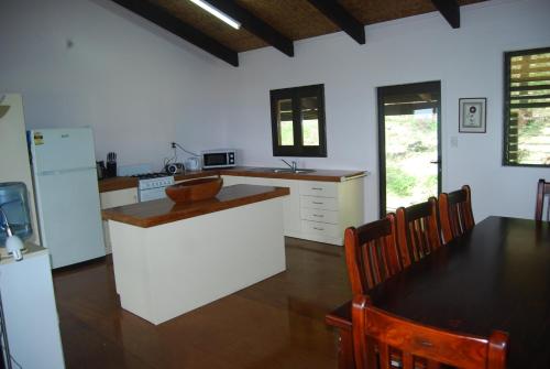 阿鲁坦加艾图塔基莫阿纳别墅的一间带桌子的厨房和一间带白色家电的厨房