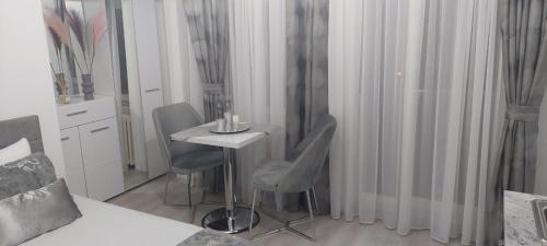 斯科普里City Lux Apartments的配有桌子和两把椅子及一张床的房间