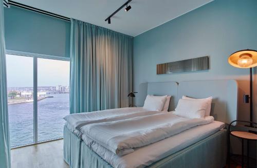 赫尔辛堡Scandic Oceanhamnen的一间卧室设有一张大床和大窗户