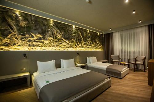 埃尔祖鲁姆The Erzurum Hotel的酒店客房设有两张床,墙上挂有绘画作品
