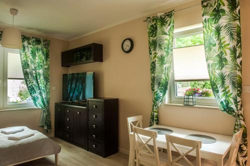 波兰尼卡-兹德鲁伊Apartament Polaniczanka的一间卧室配有桌椅和2个窗户。