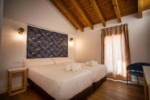 特里亚卡斯特拉Hotel Alda Triacastela的一间卧室配有一张带白色床单的床和一扇窗户。