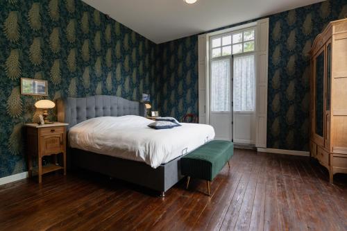 迪尔森-斯托科姆Villa les Bruyères的一间卧室配有一张床、一张桌子和一个窗户。