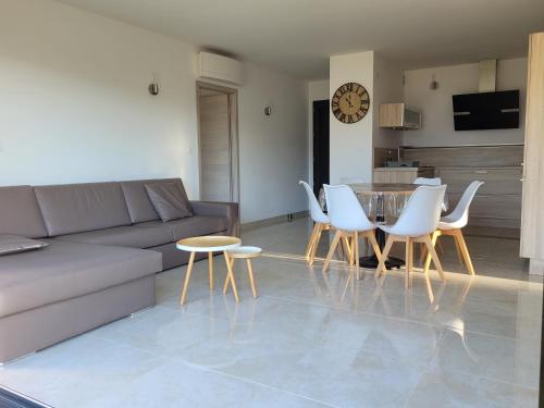 普罗普里亚诺Appartement neuf 3 chambres vue mer Propriano的客厅配有沙发和桌椅