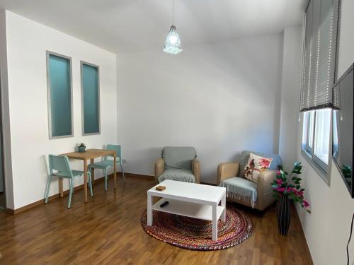 帕福斯Lovely studio apartment in Pafos的客厅配有两把椅子和一张桌子