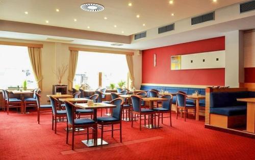 耶塞尼克Hotel Slovan的一间在房间内配有桌椅的餐厅