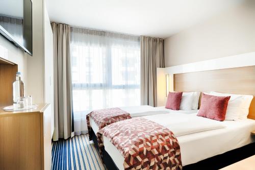 美因河畔法兰克福Best Western Plus Welcome Hotel Frankfurt的一间设有大床和窗户的酒店客房