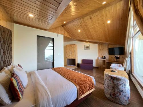 Mundaghat Kufri Pacific Resort的一间卧室配有一张床,并在一间客房内配有电视。