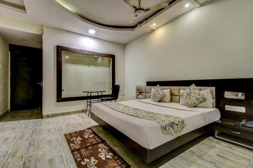 博帕尔FabHotel CSFC Near Bhopal Railway Station的一间卧室设有一张大床和大窗户