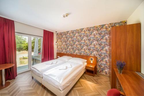 托考伊Hotel Csillag Tokaj的一间卧室设有一张床和一个大窗户