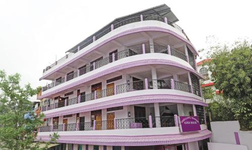 西隆Itsy Hotels Shillong Tower Guesthouse的一座高大的紫色建筑,设有阳台和树木