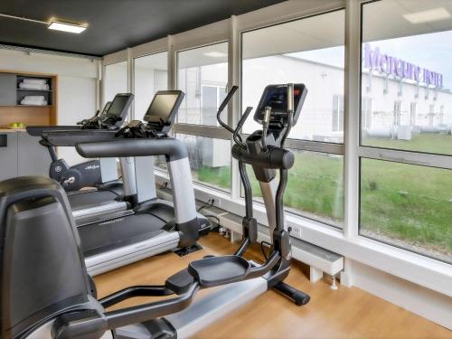 汉诺威汉诺威欧德堡大道美居酒店的健身房设有3台跑步机和窗户