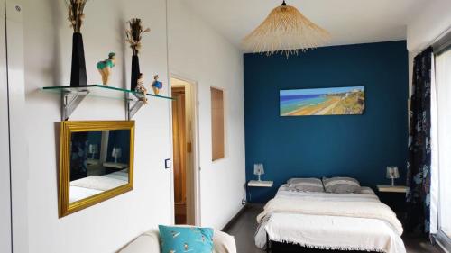 比亚里茨Belle Suite Apt的一间卧室设有蓝色的墙壁、一张床和镜子