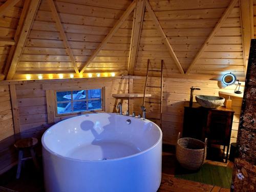 Auriac-sur-VendinelleLes Etoiles de Morphée的一个带木制天花板的房间内的大浴缸