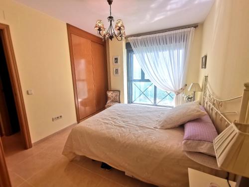 里亚萨Apartamento de 3 dormitorios con piscina - Riaza Vacacional的一间卧室设有一张大床和大窗户