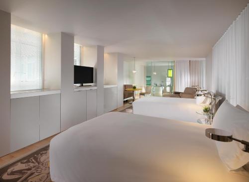 伦敦Sanderson London的酒店客房设有两张床和电视。