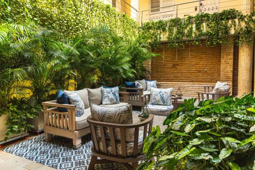 卡塔赫纳Hotel Casa Canabal by Faranda Boutique的庭院里种有椅子、树木和植物