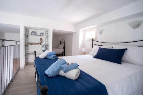 马蒂纳塔Nonna Pulsana的卧室配有带蓝色枕头的大型白色床