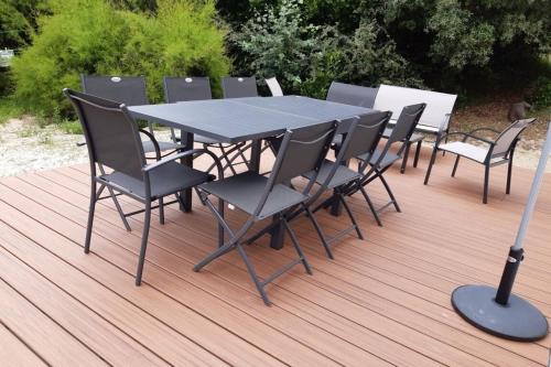基伯龙Maison Tamaris avec jardin et clos的木制甲板上的一张黑桌子和椅子