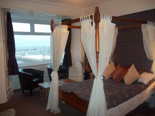 桑德兰巴尔莫勒尔露台旅馆的卧室配有带白色窗帘的床和窗户。