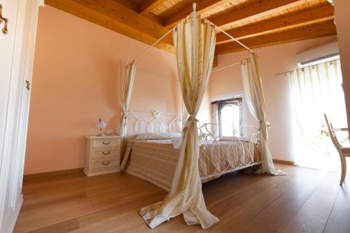 圣费利切德尔贝纳科Barchi Resort - Apartments & Suites的一间卧室配有一张带天蓬的床