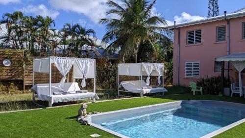 圣弗朗索瓦Villa Rosa Karibella的一个带游泳池和房子的后院