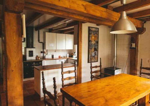 EstolloCasa de Campo La Solana的一间带木桌的厨房和一间餐厅