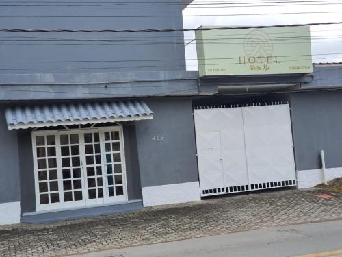 瓜拉雷马Hotel Beira Rio Guararema的两扇白色门的建筑,上面有标志